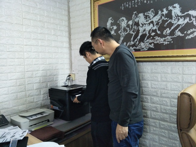 技术人员演示小型打印机操作